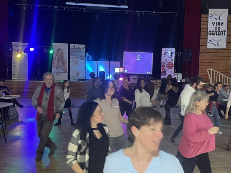 Invités sur la piste de danse lors d'une soirée animée dans une salle des fêtes