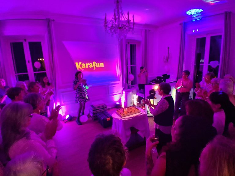 Soirée karaoké dans une salle de réception éclairée en violet, avec enseigne lumineuse