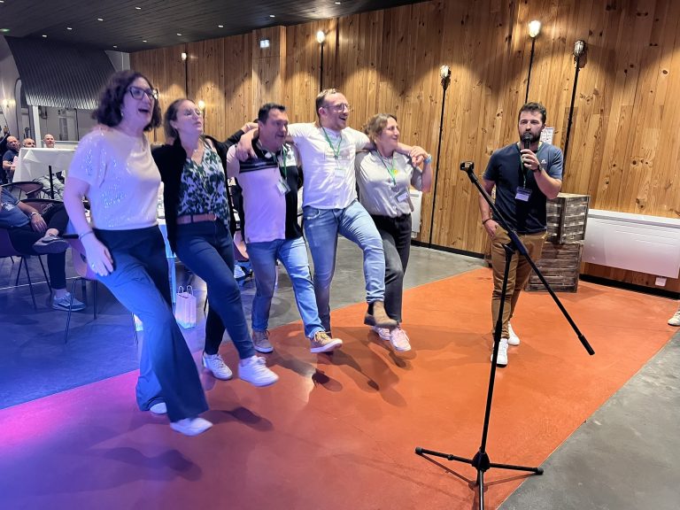 Groupe d'amis dansant près du micro dans une salle de réception boisée