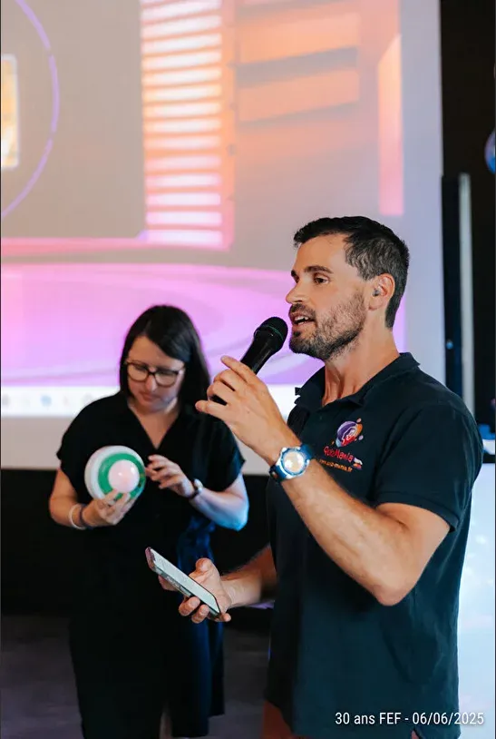 Speaker au micro lors des 30 ans d’une entreprise, aux côtés d’une collaboratrice