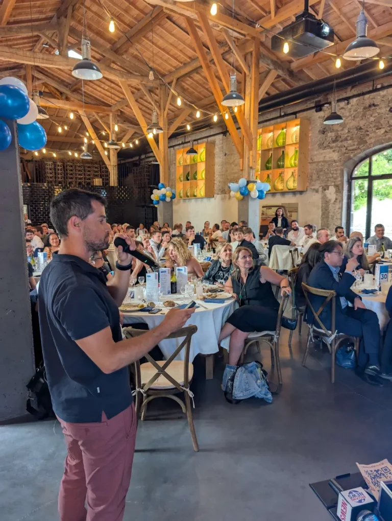 Speaker au micro pendant un repas d’entreprise sous une charpente en bois