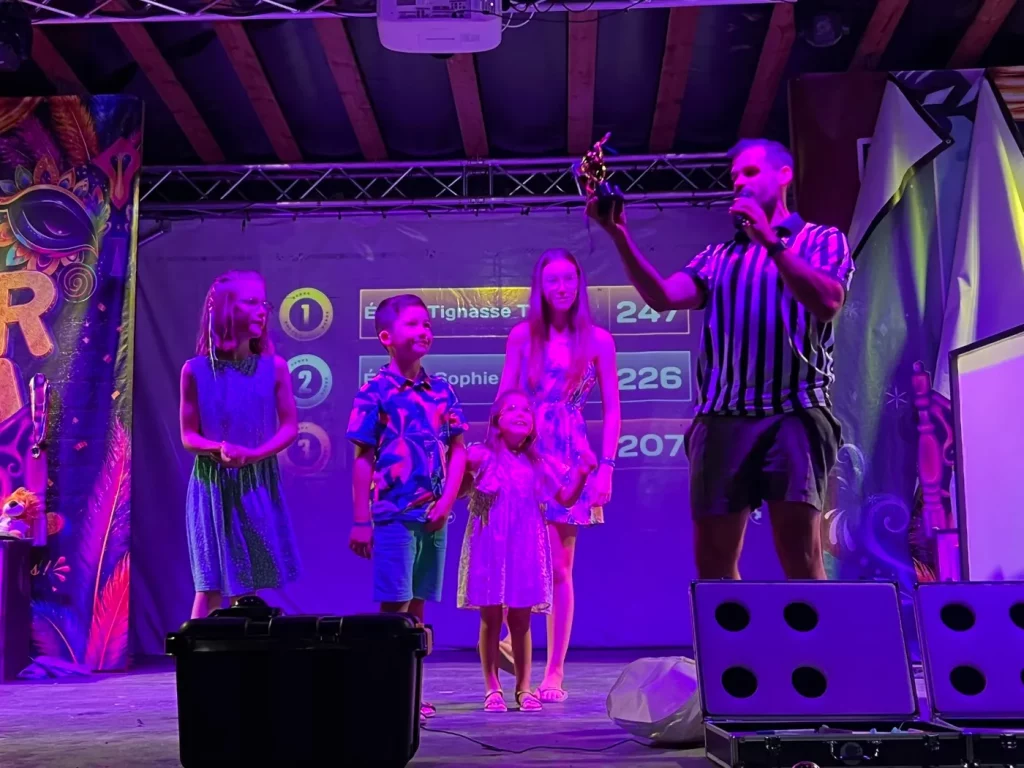 Speaker sur scène sous des lumières violettes pendant un spectacle