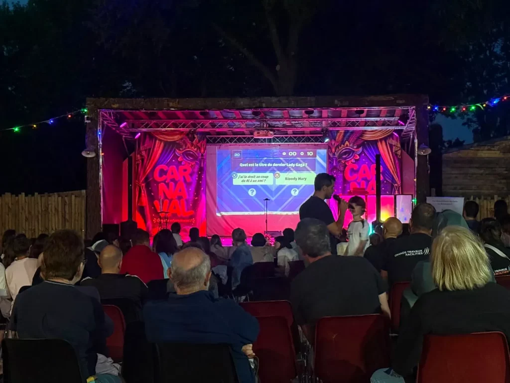 Scène en plein air illuminée lors d’un événement grand public animé au micro